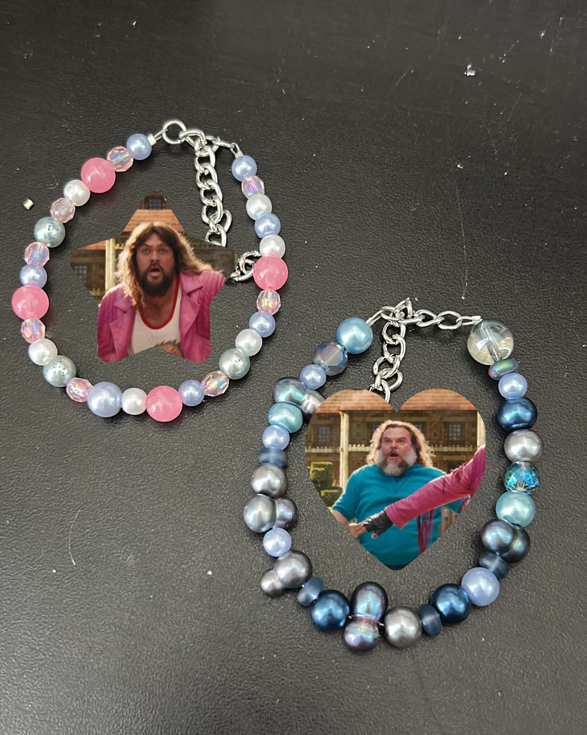 Two matching bracelets with multicolored beads and metallic chains, featuring an image of a character from the video game Minecraft displayed within a heart-shaped frame.