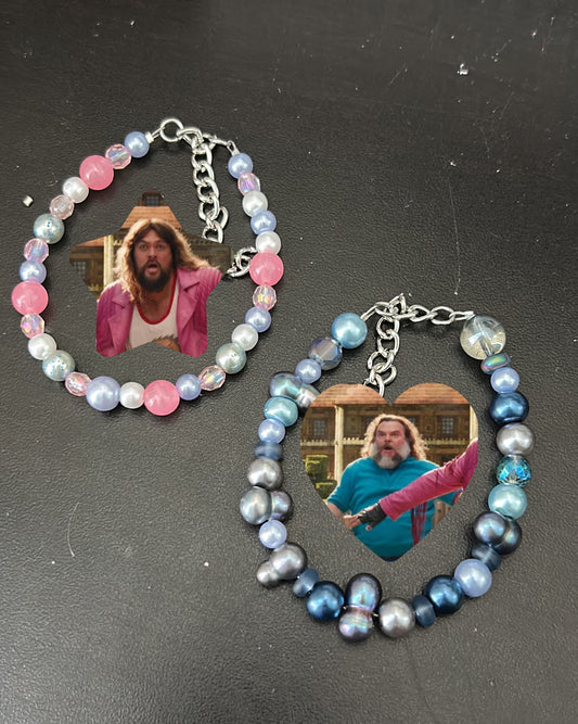 Two matching bracelets with multicolored beads and metallic chains, featuring an image of a character from the video game Minecraft displayed within a heart-shaped frame.